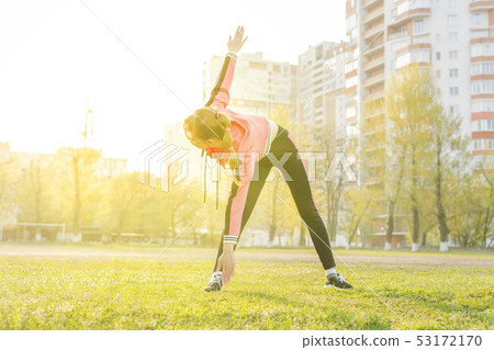 woman stretches bending over to the foot 53172170