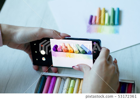 A girl takes on the smartphone multicolored chalks A girl takes on the smartphone multicolored chalks 53172361