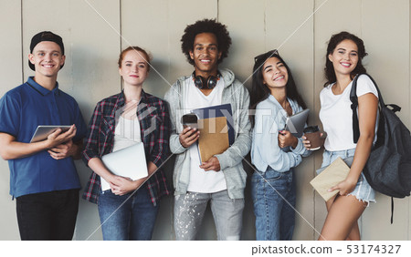 Multiethnic group of cheerful young students standing together Multiethnic group of cheerful young students standing together 53174327