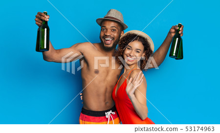Couple holding beer bottles and celebrating summer vacation Couple holding beer bottles and celebrating summer vacation 53174963