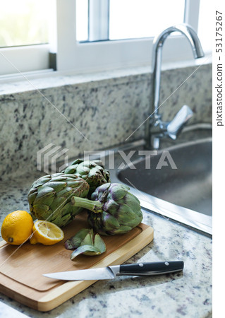 Fresh artichokes in kitchen interior Fresh artichokes in kitchen interior 53175267
