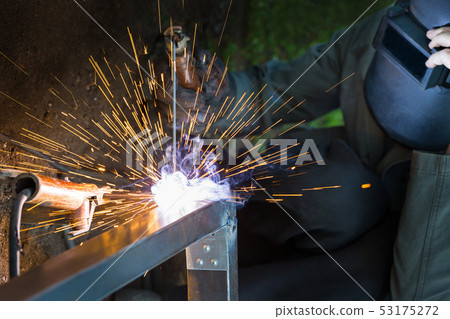 Worker in protective mask welding steel railings Worker in protective mask welding steel railings 53175272