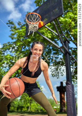 Beautiful sexy fitness girl in black sport wear with perfect body with basket ball at basketball Beautiful sexy fitness girl in black sport wear with perfect body with basket ball at basketball 53175629