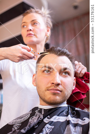 Master cuts man's hair in the salon. Scissors, Roschetsk close-up. Concept hairdressing, haircut 53176161