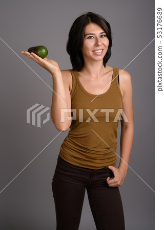 Young beautiful woman against gray background Young beautiful woman against gray background 53176689
