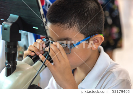 asian boy use microscope to see small living asian boy use microscope to see small living 53179405