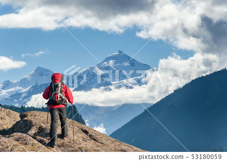 Mountaineer with backpack on rock 53180059