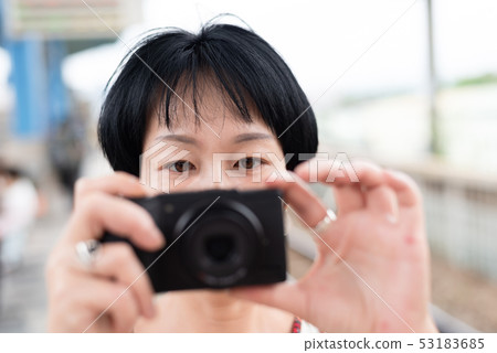 mature Asian woman using digital camera mature Asian woman using digital camera 53183685