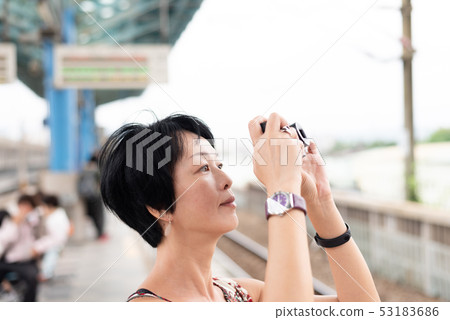mature Asian woman using digital camera mature Asian woman using digital camera 53183686