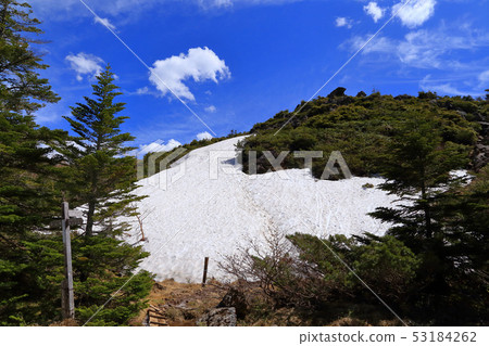 豎立路標和殘余雪在一個山小屋前面在Yatsugatake附近在Nakayama通行證在春天 53184262
