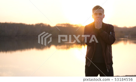 Surprised emotional man looking into the camera. Portrait of a handsome young guy on the beach 53184556