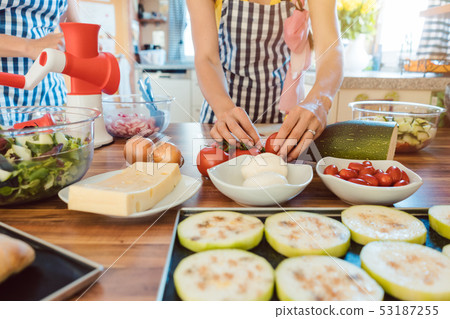 Women preparing dishes for garden party in the kitchen Women preparing dishes for garden party in the kitchen 53187255