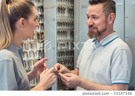 Man and woman locksmith with lots of key blanks Man and woman locksmith with lots of key blanks 53187348