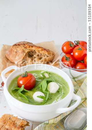 Arugula and tomatoes puree soup in white bowl Arugula and tomatoes puree soup in white bowl 53189384