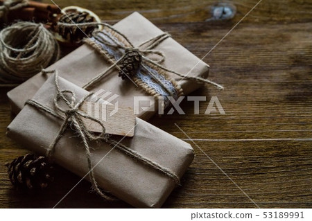Presents in rustic wrap, wood background Presents in rustic wrap, wood background 53189991