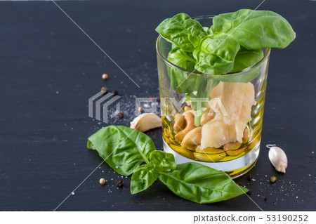 Pesto and ingredients on dark stone background Pesto and ingredients on dark stone background 53190252