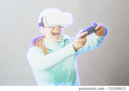 Woman with virtual reality headset is playing game. Image with hologram effect. 53190615