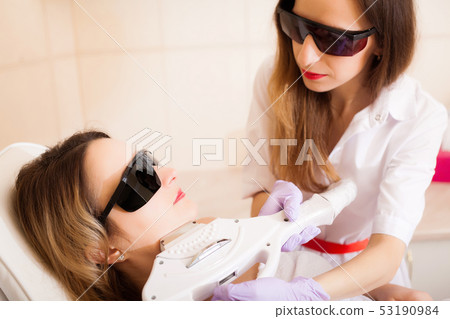Body Care. Close-up of Beautician Giving Laser Epilation Treatment To Young Woman Face Body Care. Close-up of Beautician Giving Laser Epilation Treatment To Young Woman Face 53190984