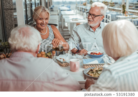 Positive delighted elderly couple having dinner outside 53191380