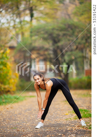 Fitness Girl. Young woman doing exercises in the park. 53191422