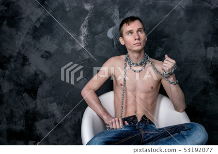 Handsome skinny guy holding a chain. Black Handsome skinny guy holding a chain. Black 53192077