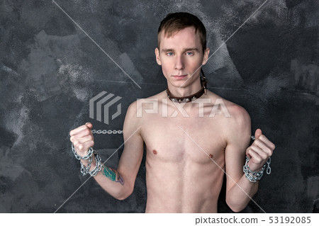 Handsome skinny guy in collar holding a chain. 53192085