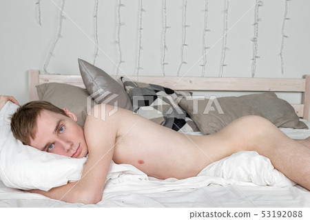 Handsome young adult man sleeping in bed. Sexy naked guy is resting Handsome young adult man sleeping in bed. Sexy naked guy is resting 53192088