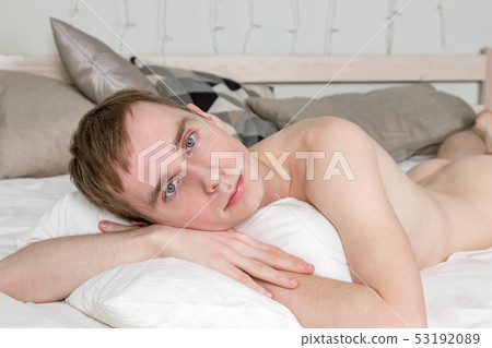 Handsome young adult man sleeping in bed. Sexy naked guy is resting Handsome young adult man sleeping in bed. Sexy naked guy is resting 53192089