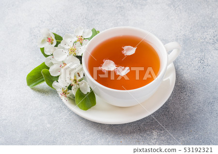 Cup of tea and blooming Apple branch on a gray  53192321