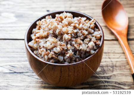 Boiled buckwheat in a wooden bowl on the village Boiled buckwheat in a wooden bowl on the village 53192539