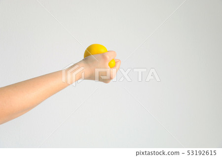 Hand press yellow squishy ball for exercise muscle 53192615