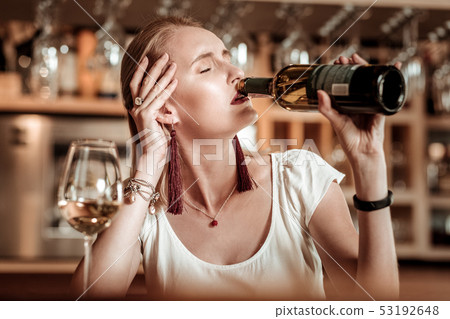 Upset young female person drinking wine alone 53192648