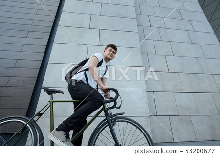 Handsome hipster man posing with bicycle in the city. 53200677