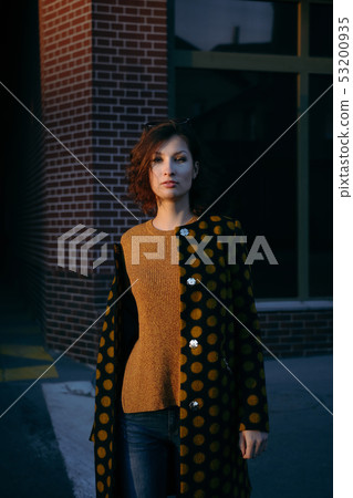 Young woman is wearing polka dot coat 53200935