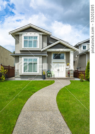 Small family house with curved concrete pathway over green lawn of front yard Small family house with curved concrete pathway over green lawn of front yard 53201895
