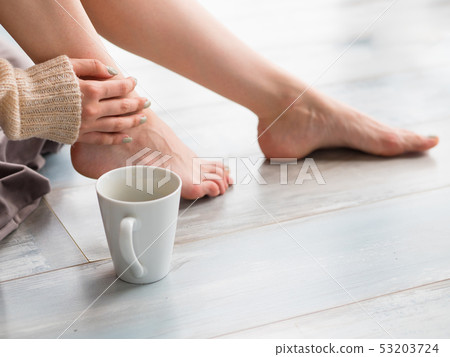 Female feet and a cup of tea or coffee Female feet and a cup of tea or coffee 53203724