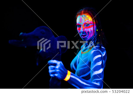 Portrait of Young naked bodyarted savage woman in blue glowing ultraviolet paint with primeval Portrait of Young naked bodyarted savage woman in blue glowing ultraviolet paint with primeval 53204022