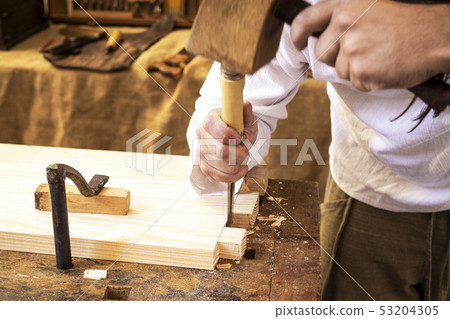 carpenter's hands working a piece of wood 53204305