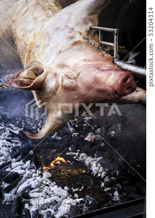 pork skewered on an iron cooking on coals 53204314