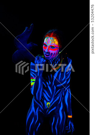 Portrait of Young naked bodyarted woman in blue glowing ultraviolet paint with tomahawk ancient Portrait of Young naked bodyarted woman in blue glowing ultraviolet paint with tomahawk ancient 53204476
