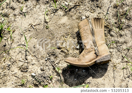 small dirty western cowboy boot on dry ground small dirty western cowboy boot on dry ground 53205313