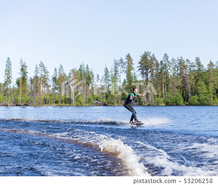 Young pretty slim brunette woman in wetsuit riding Young pretty slim brunette woman in wetsuit riding 53206258