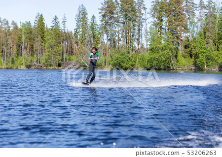 Young pretty slim brunette woman in wetsuit riding 53206263