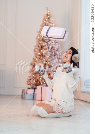 Beautiful young girl in a white dress throws up a gift. Beautiful young girl in a white dress throws up a gift. 53206489