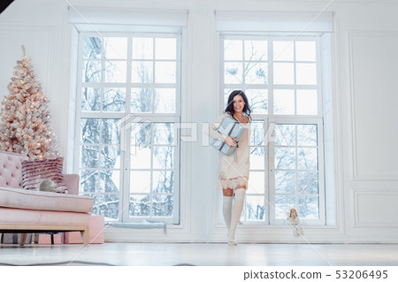 Beautiful young girl in white dress posing on camera. Christmas concept Beautiful young girl in white dress posing on camera. Christmas concept 53206495