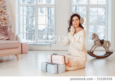 Beautiful young girl with gifts against the window. Christmas concept 53206508