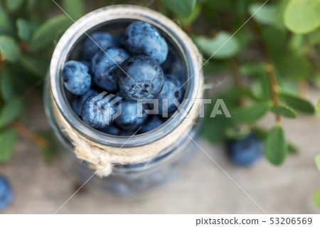 Fresh raw blueberries with leaves on wooden Fresh raw blueberries with leaves on wooden 53206569