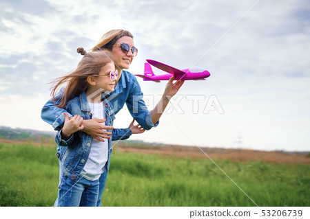 Mother and daughter playing with toy plane 53206739