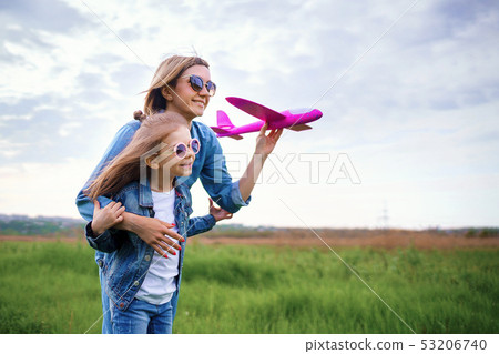 Mother and daughter playing with toy plane 53206740