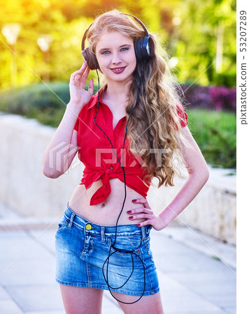 Girl in headphones and denim listens to music with closed eyes Girl in headphones and denim listens to music with closed eyes 53207289